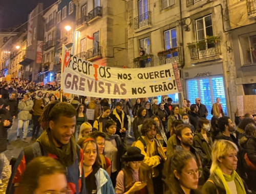 Pessoas caminhanda em protesto do 8 de março de 2022 em Lisboa, Portugal