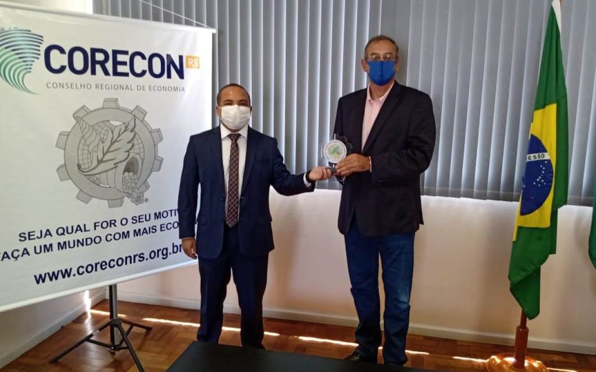 Docente recebe o troféu das mãos do economista Mário de Lima - Foto: Corecon-RS