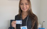 Mulher segurando carteira profissional de Administradora - fonte https://api.crars.org.br/media/Carteira%20de%20estudante.jpg