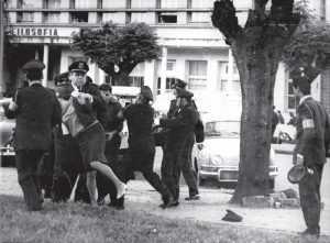 Fotografia da edição impressa do Jornal da Universidade de dezembro de 2008, mostrando estudantes da UFRGS em protesto em frente ao prédio da Filosofia e sendo reprimidos pela Guarda Civl