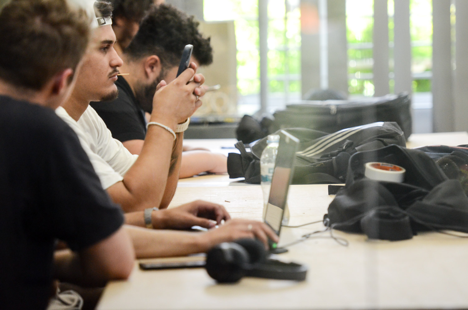 Ampliação nas oportunidades de estudo no Ensino Médio e universitário também aumentou ingresso de pessoas que precisam trabalhar para manter frequência e permanência na universidade. Na imagem, jovens desenvolvem atividades em grupo envolvendo notebooks e computadores