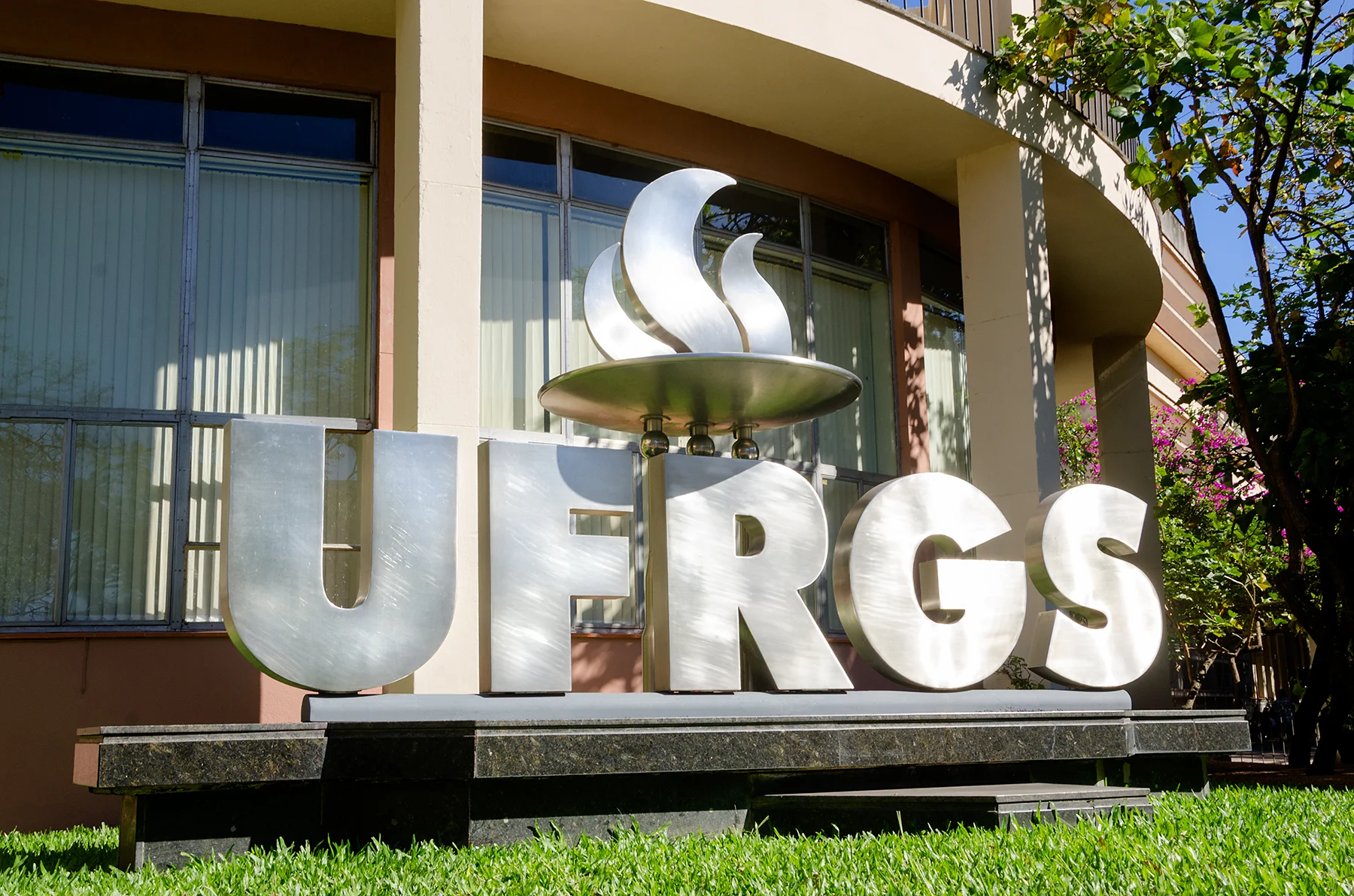 Logo da UFRGS em letras-caixa em frente ao Prédio da Reitoria